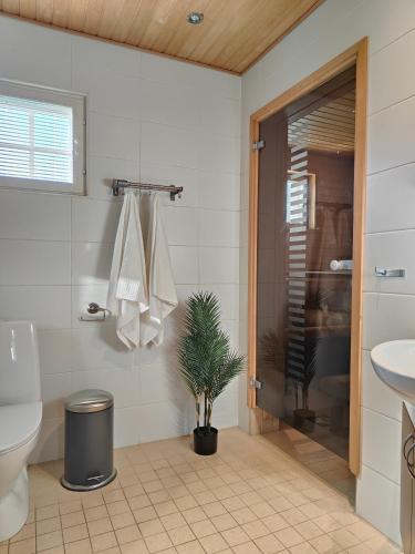 a bathroom with a toilet and a plant in it at The Sunny Villa in Kokkola