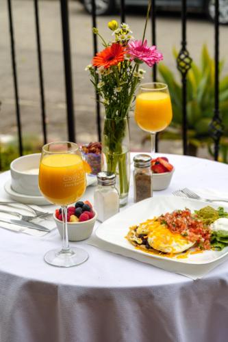 a table with a plate of food and two glasses of orange juice at The Eagle Inn in Santa Barbara