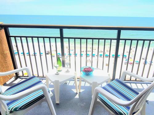 a balcony with a table and chairs and the beach at Ocean Front King Suit Myrtle Beach Heated Pools Landmark in Myrtle Beach