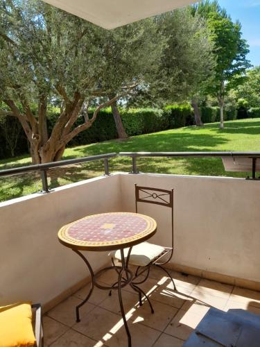 une table et une chaise sur un balcon dans l'établissement studio avec parking Montpellier, à Montpellier