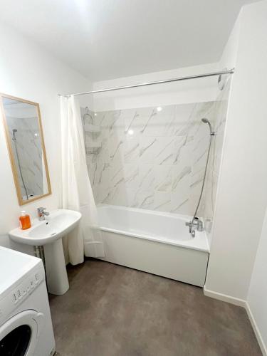 une salle de bain blanche avec une baignoire et un lavabo dans l'établissement Idéal emplacement à Drancy, à Drancy