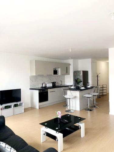 un salon avec un canapé et une cuisine dans l'établissement Idéal emplacement à Drancy, à Drancy