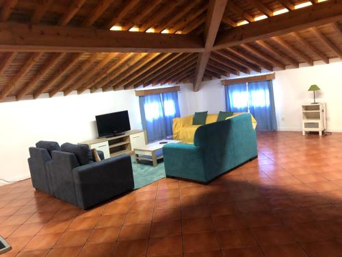 ein Wohnzimmer mit zwei Stühlen und einem Fernseher in der Unterkunft Casa da Fajã in Ponta Delgada