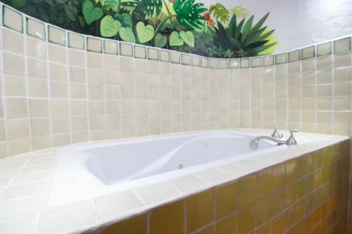 a bath tub in a bathroom with green plants at Finca Rosa Blanca Coffee Farm and Inn in Heredia