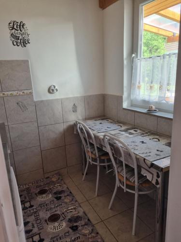 a room with a table and chairs in a bathroom at Napfény Apartman in Bogács