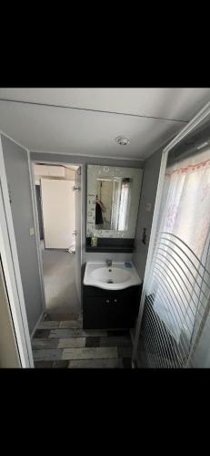 une salle de bain avec un lavabo et un miroir dans l'établissement L éden, à Hyères