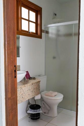 a bathroom with a toilet and a sink and a shower at Villa Cottage Pousada in Monte Alegre do Sul