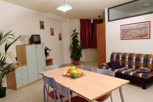 a living room with a table with a bowl of fruit on it at Residenza La Passeggiata in Trevi