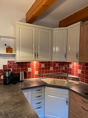 a kitchen with white cabinets and a sink at Ferienwohnung Attwengerhof in Traunkirchen