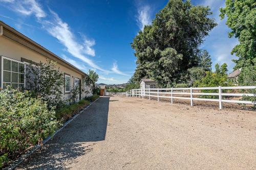 a dirt road next to a white fence at The Oaktree Estate by Fieldtrip 7 Acre Private Resort with Lake Pool Vineyard in Lake Elsinore