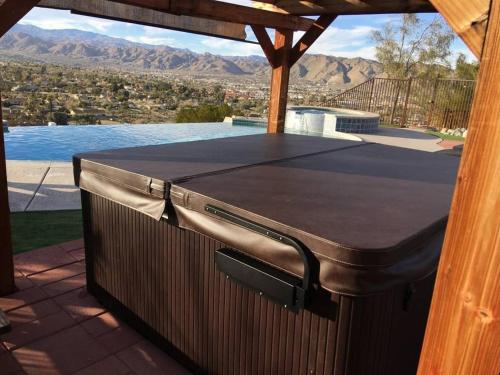 a hot tub on a patio with a view of the mountains at Sunset House Joshua Tree Infinity Pool Spa Views Hiking Trail in Yucca Valley