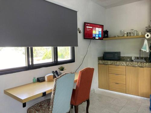 a room with a desk with two chairs and a television at Estudio en García Gineres in Mérida