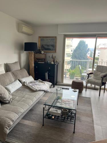 un salon avec un canapé et une table en verre dans l'établissement Chambre cosy dans T3, à Cannes