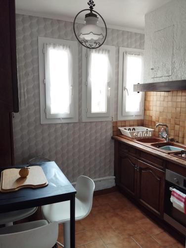 - une cuisine avec un évier et une table ainsi que 2 fenêtres dans l'établissement Great Base to explore Alès, à Alès
