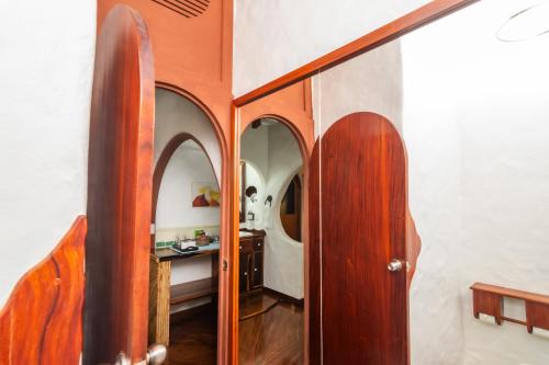 a hallway with wooden doors and a room with a bed at Finca Rosa Blanca Coffee Farm and Inn in Heredia