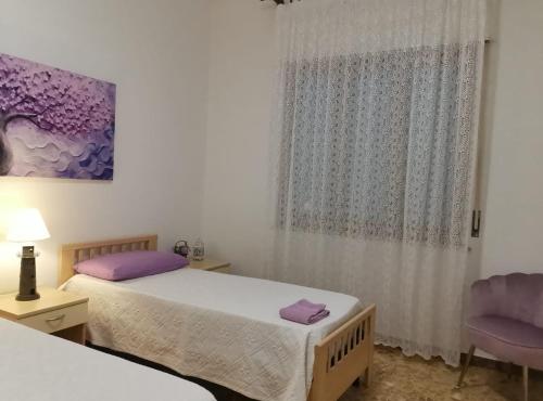 a bedroom with two beds and a window at App.Violet Sardegna Mare La Caletta in La Caletta