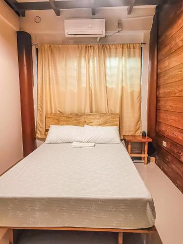 a bedroom with a large bed with a window at Camote's Lake Retreat in Cavinti