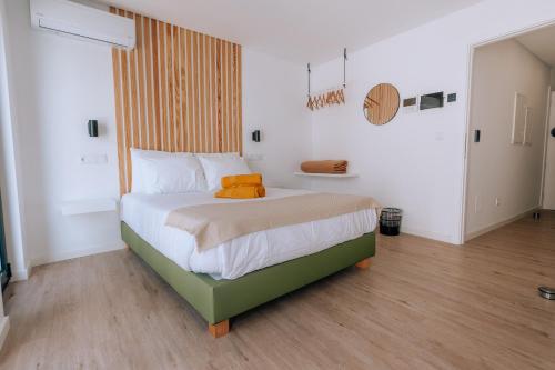 a bedroom with a bed with an orange pillow on it at Azores Smart Studios in Ponta Delgada
