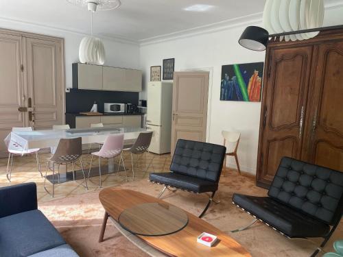 Una sala de estar con mesa y sillas y una cocina. en La Feuilleraie, en Tours