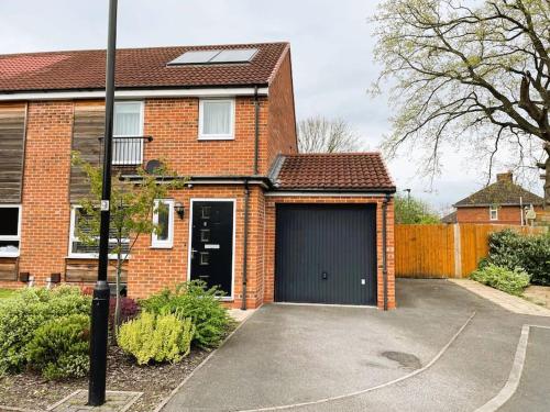 a brick house with a garage with a black door at 3 bed house near York centre with off road parking in York