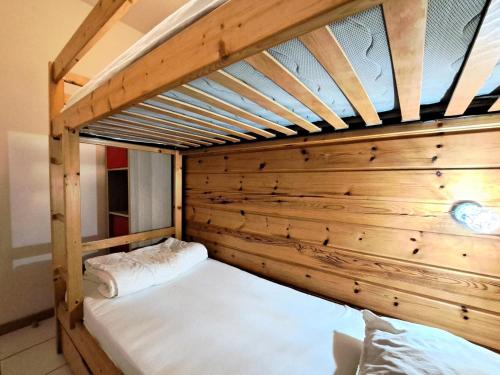 Ce lit superposé se trouve dans un dortoir doté de murs en bois. dans l'établissement Les Chalets de Flaine Hameau - maeva Home - Chalet 3 Pièces 8 Personnes - Confort MAE-3392, à Flaine