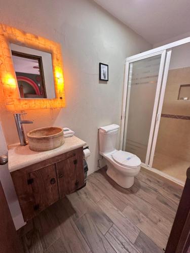 a bathroom with a toilet and a sink with a mirror at Hotel Spa Casa del Sol in Guanajuato