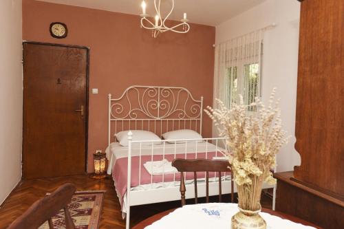 a bedroom with a white bed and a table at Villa Terrazza in Donji Morinj