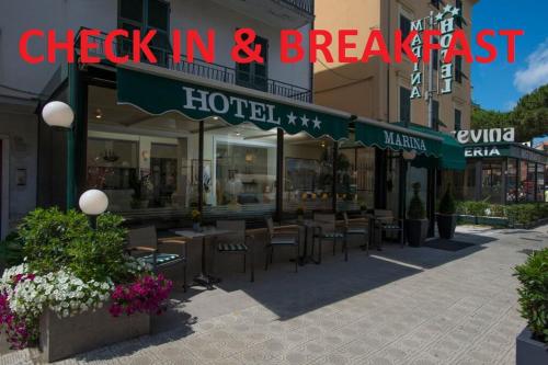 Un restaurante con mesas y sillas frente a un edificio. en Marina B&B Adults Only, en Sestri Levante