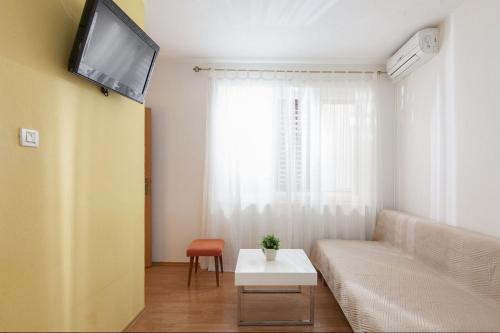 a living room with a couch and a tv at Apartments Agneza Tucepi in Tučepi