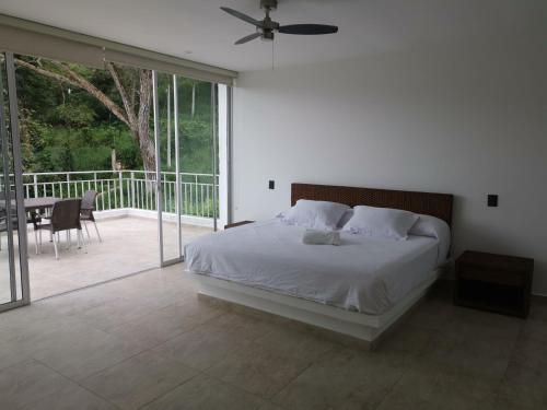 a bedroom with a white bed and a balcony at Montecarlo Club in La Mesa