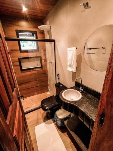 a bathroom with a toilet and a sink in a room at Pousada Recanto da Concha in Itacaré