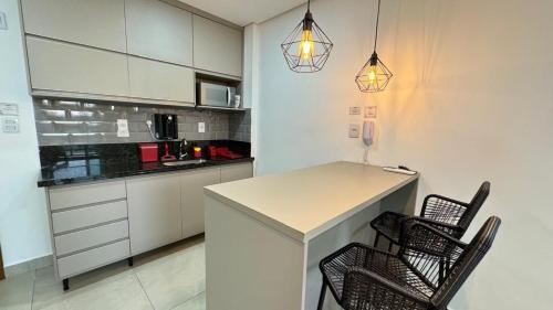 a kitchen with a table and two chairs in it at Monte Carmel in Ribeirão Preto