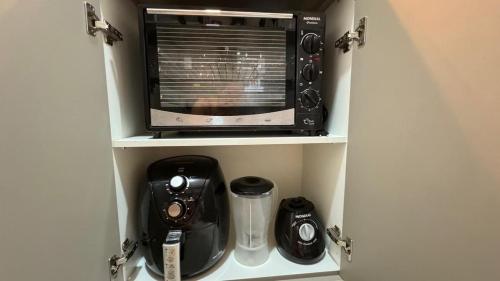 a kitchen cupboard with a microwave and a blender at Monte Carmel in Ribeirão Preto