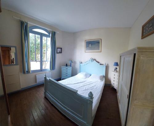 une chambre avec un lit bleu et une fenêtre dans l'établissement Séjour plage en tribu, Maison Étoile Pascale Confort convivialité, proximité mer À 5 min de la plage de Trojan les Bains, Parfait pour week-end ou vacances en groupe, à Saint-Trojan-les-Bains