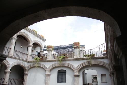 a building with a balcony with potted plants on it at Casa 1810 Hotel Boutique in San Miguel de Allende