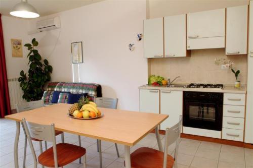 a kitchen with a table with a bowl of fruit on it at Residenza La Passeggiata in Trevi