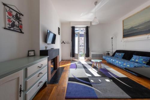 - un salon avec un canapé bleu et un tapis bleu dans l'établissement Le Saint-Louis 1, Terrasse, Cosy, cœur de ville bord de Loire, commerces à pied, à Gien