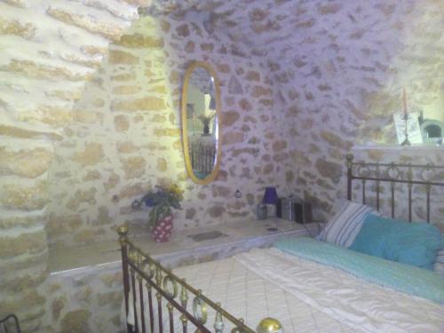 une chambre avec un lit dans un mur de pierre dans l'établissement Bergerie small loft prés d'Aix en Provence, à Jouques