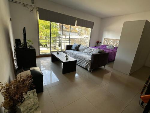 a living room with a couch and a table at Lovely & Lightful Studio with pool in San Fernando