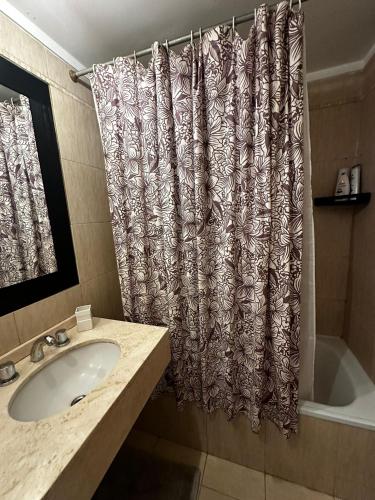 a bathroom with a sink and a shower curtain at Lovely & Lightful Studio with pool in San Fernando