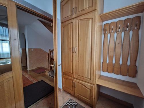 a room with a closet with wooden cabinets and a staircase at Apartamenty - Dom w Górach in Kluszkowce