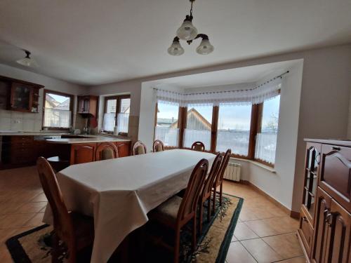 a kitchen and dining room with a table and chairs at Apartamenty - Dom w Górach in Kluszkowce