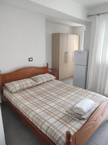 a bedroom with a bed and a refrigerator at Villa Janilla in Dhërmi