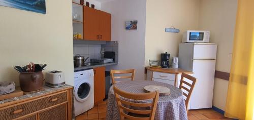 une petite cuisine avec une table et un réfrigérateur dans l'établissement Cottage du Golf en Morbihan, à Ploemel