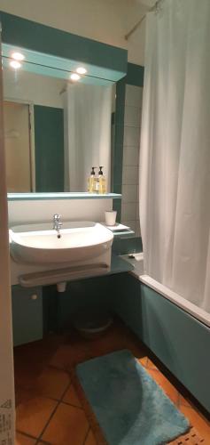 a bathroom with a sink and a mirror at Cottage du Golf en Morbihan in Ploemel