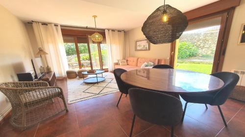 a living room with a wooden table and chairs at Vut "mar a poo" in poo de Llanes