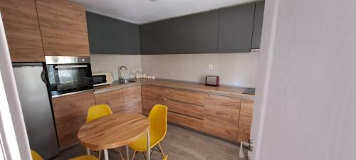 a kitchen with a wooden table and yellow chairs at Vila Felicita in Sremski Karlovci