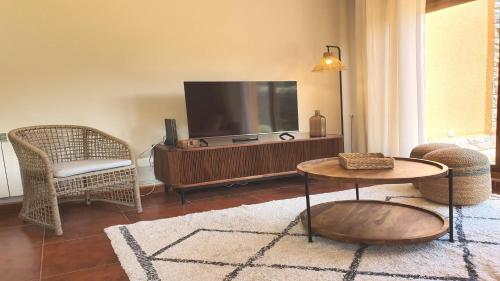 a living room with a television and a table and chairs at Vut "mar a poo" in poo de Llanes