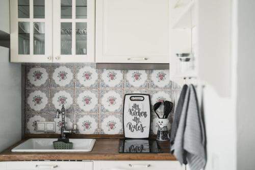 a kitchen with white cabinets and a sink at The Garden House in Kavála