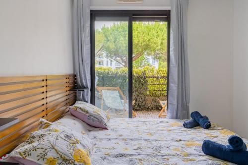 - une chambre avec un lit et une grande porte en verre dans l'établissement Le Borely, côté Marina Olympique, à Marseille